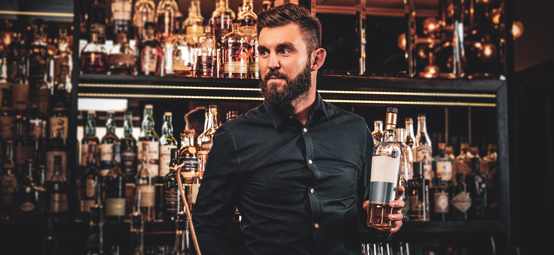 Elegant happy bar owner is making special drink for his customers at his own bar.